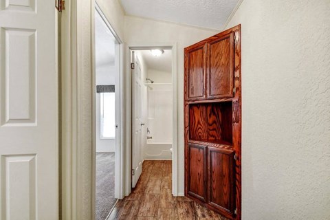 a bedroom with a wooden door and a hallway to a bathroom